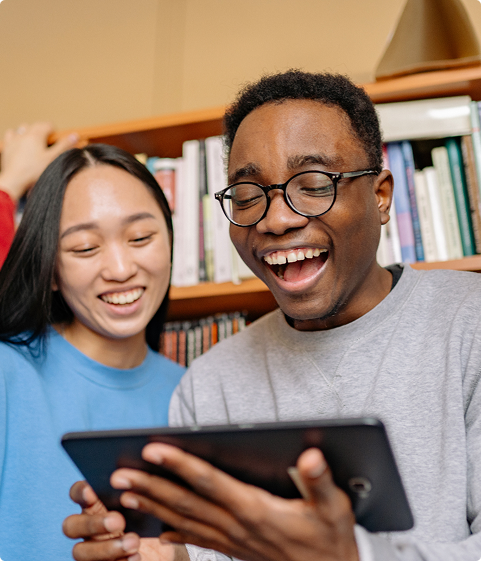 Two young adults indoors studying with a tablet